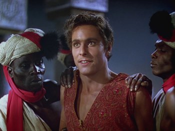 Movie still from “The Thief of Bagdad” (1940), directed by Alexander Korda – A man in a red shirt is posing for a picture; Close Up shot, Over the shoulder angle