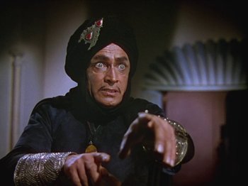 Movie still from “The Thief of Bagdad” (1940), directed by Alexander Korda – A man wearing a turban and holding a cane; Medium shot, Low angle
