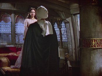 Movie still from “The Thief of Bagdad” (1940), directed by Alexander Korda – A woman standing in front of a man in a room; Wide shot, Over the shoulder angle