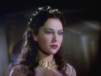 Movie still from “The Thief of Bagdad” (1940), directed by Alexander Korda – A woman with long dark hair wearing a crown of flowers; Close Up shot, Over the shoulder angle