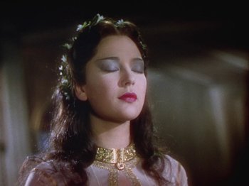 Movie still from “The Thief of Bagdad” (1940), directed by Alexander Korda – A young woman with long dark brown hair wearing a gold necklace; Close Up shot, Low angle