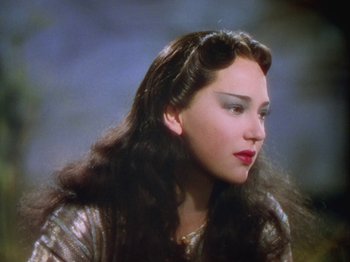 Movie still from “The Thief of Bagdad” (1940), directed by Alexander Korda – A woman with long black hair wearing a silver dress; Close Up shot, Over the shoulder angle