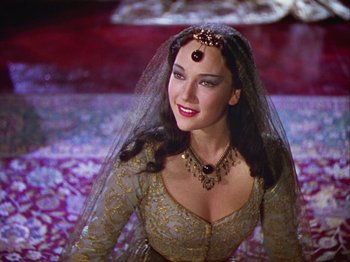 Movie still from “The Thief of Bagdad” (1940), directed by Alexander Korda – A woman in a gold dress with a veil on her head; Close Up shot, High angle