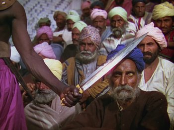 Movie still from “The Thief of Bagdad” (1940), directed by Alexander Korda – A group of men in a crowd holding a sword; Medium shot, High angle