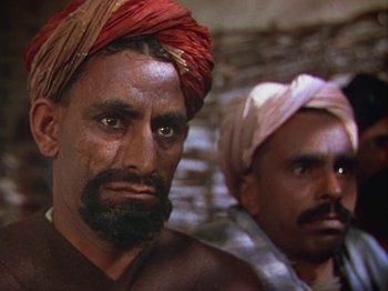 Movie still from “The Thief of Bagdad” (1940), directed by Alexander Korda – A man with a beard and a red turban on his head and another man with a beard and a red turban on his head; Close Up shot, Low angle