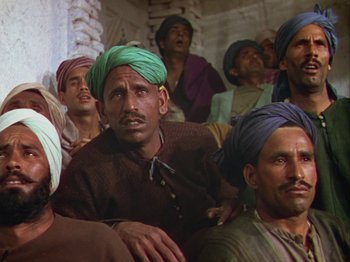 Movie still from “The Thief of Bagdad” (1940), directed by Alexander Korda – A group of men with turbans sitting next to each other; Medium shot, High angle