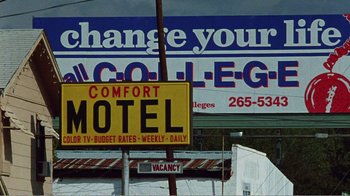 Movie still from “The Thin Blue Line” (1988), directed by Errol Morris – A motel sign with a vacancy sign in the background; Extreme Wide shot, Low angle