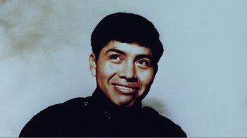 Movie still from “The Thin Blue Line” (1988), directed by Errol Morris – An old photo of a man smiling for the camera; Close Up shot, Low angle