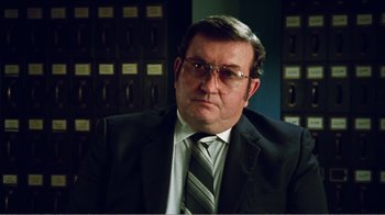 Movie still from “The Thin Blue Line” (1988), directed by Errol Morris – A person wearing a suit and tie; Close Up shot, Low angle