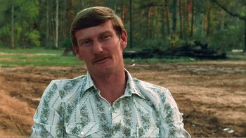 Movie still from “The Thin Blue Line” (1988), directed by Errol Morris – A person wearing a floral shirt; Close Up shot, High angle