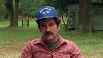 Movie still from “The Thin Blue Line” (1988), directed by Errol Morris – A man wearing a blue hat and a red shirt; Close Up shot, Low angle