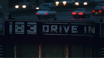 Movie still from “The Thin Blue Line” (1988), directed by Errol Morris – A street sign that reads " 1 3 drive " on the side of a building; Extreme Close Up shot, High angle