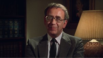 Movie still from “The Thin Blue Line” (1988), directed by Errol Morris – A person wearing a suit and tie; Close Up shot, Over the shoulder angle