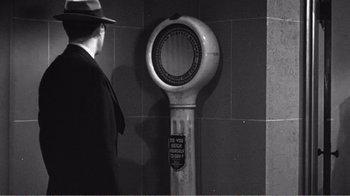 Movie still from “The Thin Blue Line” (1988), directed by Errol Morris – A man standing next to a parking meter; Medium shot, Low angle