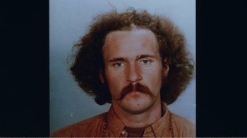 Movie still from “The Thin Blue Line” (1988), directed by Errol Morris – A person wearing a shirt and a mustache; Close Up shot, Low angle