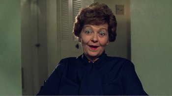 Movie still from “The Thin Blue Line” (1988), directed by Errol Morris – An older woman is smiling for the camera; Close Up shot, High angle