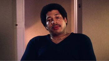 Movie still from “The Thin Blue Line” (1988), directed by Errol Morris – A person wearing a black shirt; Close Up shot, Low angle