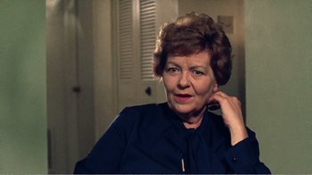 Movie still from “The Thin Blue Line” (1988), directed by Errol Morris – An older woman is posing for a picture; Close Up shot, Over the shoulder angle