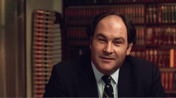 Movie still from “The Thin Blue Line” (1988), directed by Errol Morris – A person wearing a suit and tie; Close Up shot, Low angle