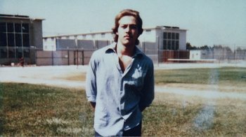 Movie still from “The Thin Blue Line” (1988), directed by Errol Morris – A man standing in a field with his hands in his pockets; Close Up shot, Low angle
