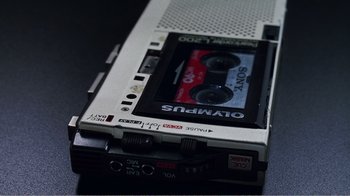 Movie still from “The Thin Blue Line” (1988), directed by Errol Morris – A cassette tape on top of an audio cassette player; Extreme Close Up shot, Overhead angle