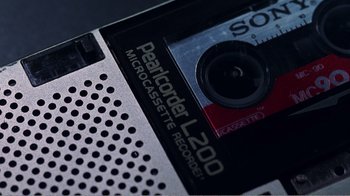 Movie still from “The Thin Blue Line” (1988), directed by Errol Morris – The back of an audio cassette tape; Extreme Close Up shot, Overhead angle