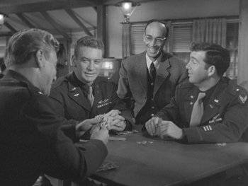 Movie still from “The Thing from Another World” (1951), directed by Howard Hawks – A group of men sitting at a table playing cards; Medium shot, Over the shoulder angle