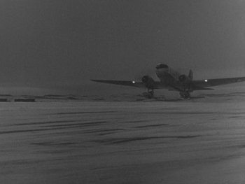 Movie still from “The Thing from Another World” (1951), directed by Howard Hawks – An airplane on a runway in the middle of the night; Extreme Wide shot, High angle