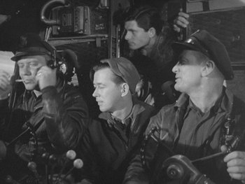 Movie still from “The Thing from Another World” (1951), directed by Howard Hawks – A black and white photo of a group of men in uniform; Medium shot, High angle