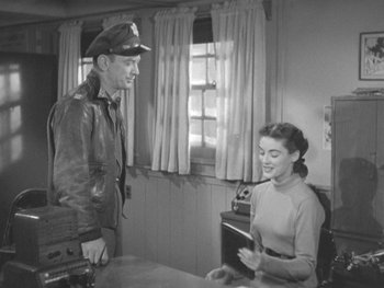 Movie still from “The Thing from Another World” (1951), directed by Howard Hawks – An old black and white photo of a man and a woman; Medium shot, High angle