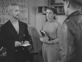 Movie still from “The Thing from Another World” (1951), directed by Howard Hawks – A man and two women standing next to each other in a room; Medium shot, Over the shoulder angle