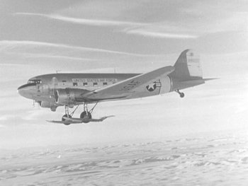 Movie still from “The Thing from Another World” (1951), directed by Howard Hawks – An airplane is flying in the sky above the clouds; Extreme Wide shot, Low angle