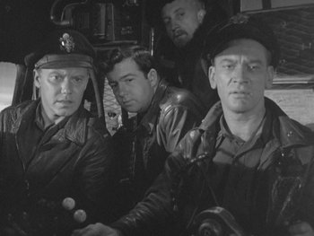 Movie still from “The Thing from Another World” (1951), directed by Howard Hawks – A black and white photo of a group of men in uniform; Medium shot, High angle