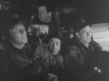 Movie still from “The Thing from Another World” (1951), directed by Howard Hawks – A black and white photo of men in uniforms; Medium shot, High angle