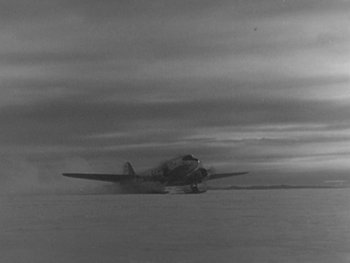 Movie still from “The Thing from Another World” (1951), directed by Howard Hawks – An airplane is flying low in the sky; Extreme Wide shot, Low angle