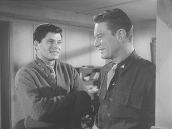 Movie still from “The Thing from Another World” (1951), directed by Howard Hawks – Two men shaking hands in an office setting; Medium shot, Over the shoulder angle