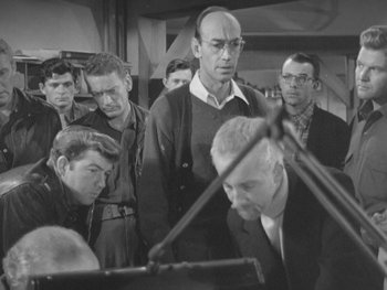 Movie still from “The Thing from Another World” (1951), directed by Howard Hawks – A black and white photo of a group of men; Medium shot, High angle