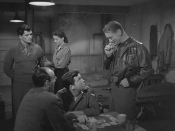 Movie still from “The Thing from Another World” (1951), directed by Howard Hawks – A group of men sitting around a table; Medium shot, Over the shoulder angle