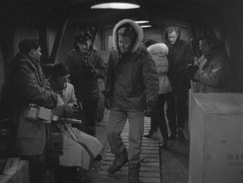 Movie still from “The Thing from Another World” (1951), directed by Howard Hawks – A group of people standing in a room; Wide shot, High angle