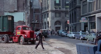 Movie still from “The Thomas Crown Affair” (1968), directed by Norman Jewison – A man walking down the street in a suit and hat; Wide shot, High angle
