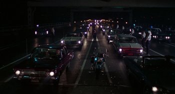 Movie still from “The Thomas Crown Affair” (1968), directed by Norman Jewison – A street filled with lots of traffic at night time; Extreme Wide shot, High angle