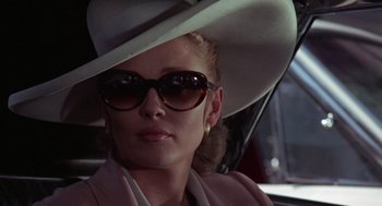 Movie still from “The Thomas Crown Affair” (1968), directed by Norman Jewison – A woman wearing a hat and sunglasses in a car; Close Up shot, Low angle