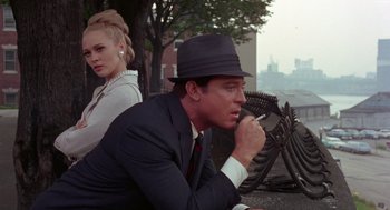 Movie still from “The Thomas Crown Affair” (1968), directed by Norman Jewison – A man and a woman sitting next to each other on a bench; Medium shot, Over the shoulder angle