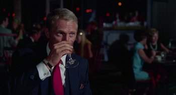 Movie still from “The Thomas Crown Affair” (1968), directed by Norman Jewison – A man in a suit and tie drinking a glass of wine; Close Up shot, Over the shoulder angle