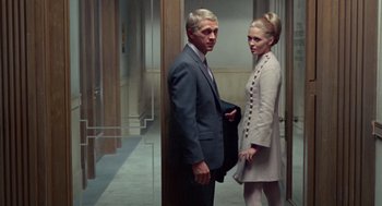 Movie still from “The Thomas Crown Affair” (1968), directed by Norman Jewison – A man and a woman standing next to each other in a hallway; Medium shot, Low angle