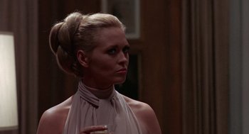 Movie still from “The Thomas Crown Affair” (1968), directed by Norman Jewison – A woman in a white dress holding a glass of wine; Close Up shot, Over the shoulder angle