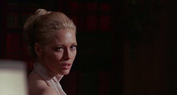 Movie still from “The Thomas Crown Affair” (1968), directed by Norman Jewison – A woman with blonde hair wearing a white top; Close Up shot, Over the shoulder angle