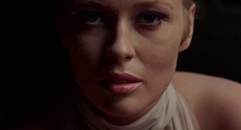 A woman's face in a dimly - lit room