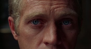 Movie still from “The Thomas Crown Affair” (1968), directed by Norman Jewison – An older man with blue eyes stares into the camera; Extreme Close Up shot, Overhead angle