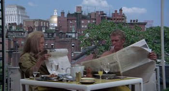 Movie still from “The Thomas Crown Affair” (1968), directed by Norman Jewison – A man and a woman sitting at an outdoor table reading newspapers; Medium shot, Over the shoulder angle